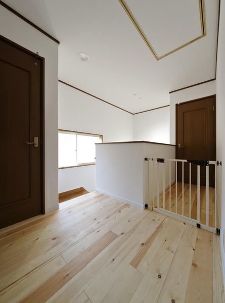 肌触りが優しい無垢パイン材を床施工した2階ホールです。珪藻土風の壁や天井はシックハウス対策仕様・防汚性能を具えたEBクロス。個室は建具を交換して新しい装いに。