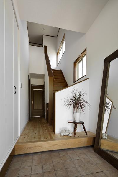 陽ざしを感じる爽やかな玄関ホールです。色や鏡の配置に工夫して、2F W.I.Cの増床で生まれた暗がりに 光が届くように。玄関には靴が沢山入る天井いっぱいの収納を新設。