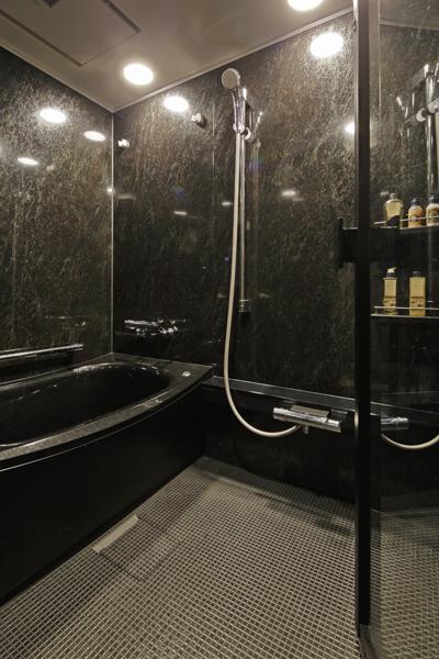 ラグジュアリーな雰囲気の浴室です。透明な扉が採用されたことで部分的に視線が抜け開放感が増しました。立ち上がりを補助するバーや手すりを設置、浴槽からの出入りをサポートします。