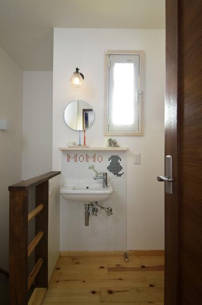 2階ホール(廊下)に造作した洗面コーナーです。手軽に手洗いできるよう主寝室の正面に配置しました。タイルパターンで愛犬「モモ」ちゃんを可愛くデザイン。「毎朝起きる度にモモにおはようと語りかけています」とH様ご夫婦。モモちゃんはいつまでもご家族と一緒 愛らしい姿でご夫婦を見守っています。