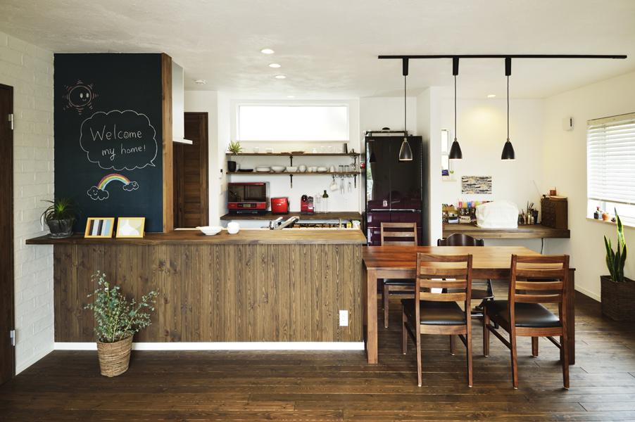 黒板塗装で遊び心をプラスしたカフェ風のDKです。キッチンの並びにはダイニングを配置。ペンダントライトでさりげなく空間を間仕切りました。奥にはミシンも置けるカウンターをご用意。