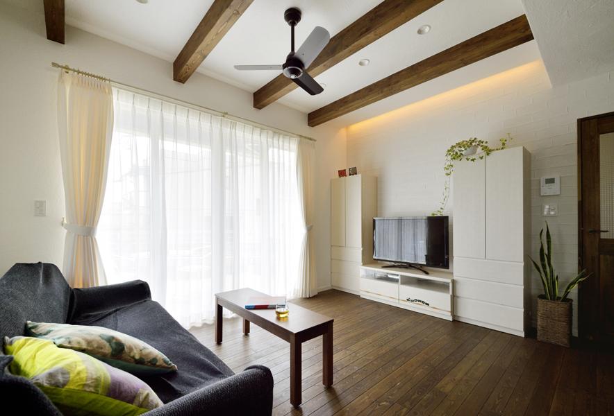 O様お気に入りのシーリングファンとあらわし梁を眺めるお洒落なリビングです。床壁はその持ち味で柔和な雰囲気を生み出す自然素材をご採用。無垢材で室内ドアを造作しました。