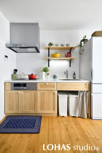 無垢材の扉が可愛らしい、お洒落なキッチンです。壁には独特の形が人気のタイルを、ブルーの扉をアクセントにするため、敢えてホワイト一色で施工しました。タイルの目地には油汚れに強いキッチン用のものをセレクト。お手入れしやすく、キレイな状態を保てます。