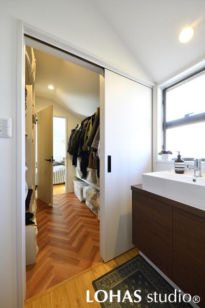 ご両親の寝室から、そのまま洗面化粧台とトイレのある廊下へ通り抜けられるウォークスルークロゼットです。子世帯のLDKに入ることなく移動ができるので、お互い気兼ねせず過ごせます。クロゼットの床はヘリンボーン張りにしてゆるやかにゾーニングしました。