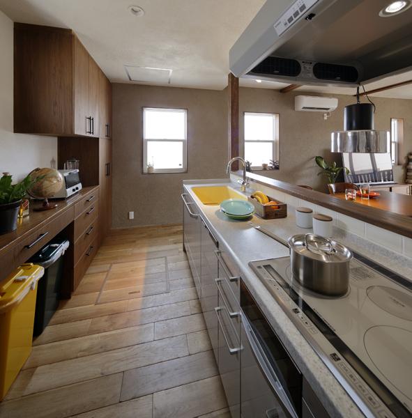 大きな収納にさまざまなツールを収めた使いやすい対面キッチンです。ピンポイントにヴィヴィッドカラーが加わり新鮮さをプラス！足元は素足も心地よいフローリングです。