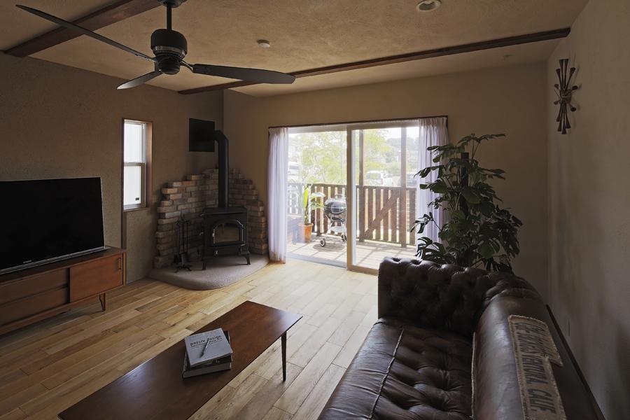 実用的なインテリアとして評価の高い「薪ストーブ」を眺めるリビングです。アンティークのソファとも抜群の相性。ウッドデッキとも地続きになる伸びやかな大空間です。