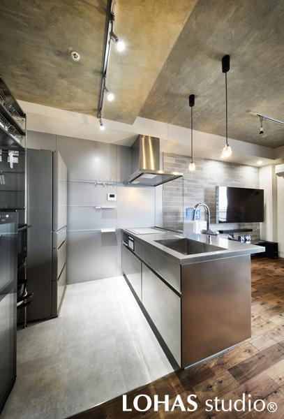 ステンレスでまとめクールな印象を受けるキッチンです。躯体表しの天井といった無骨なアイテムに合わせ、シンプルながらセンスよくまとまりました。