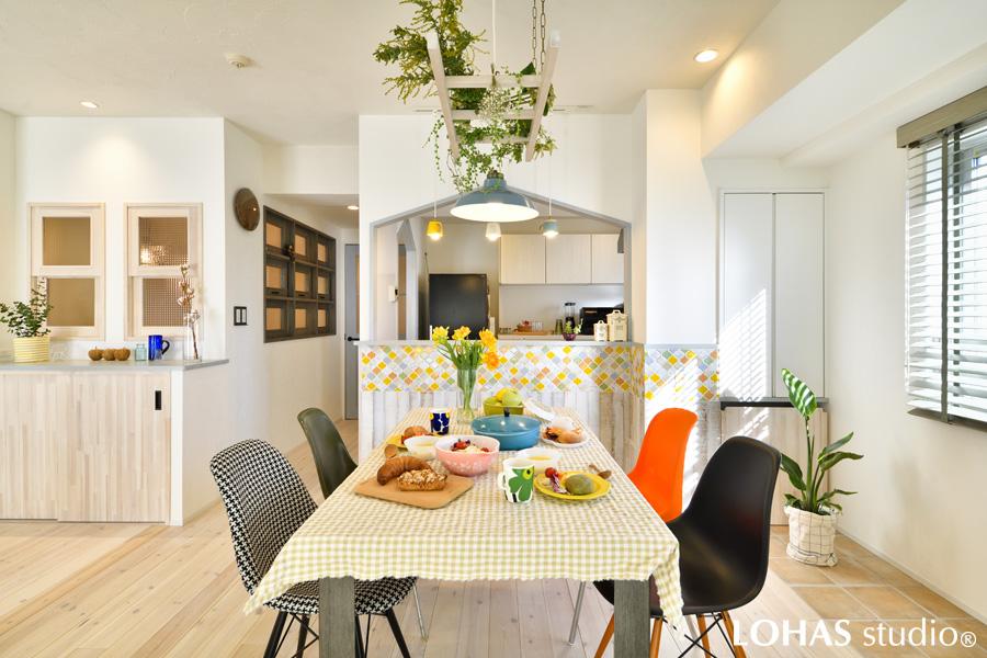 三角屋根の開口部が可愛らしいキッチンダイニングです。アクセントのタイルは全体の雰囲気に合わせ、Tさまがどうしても使いたいと仰っていたバーンオークにも馴染むようにカラーオーダーしたもの。照明もユニークなカップ型を選んで、ワクワクするスペースとなりました。