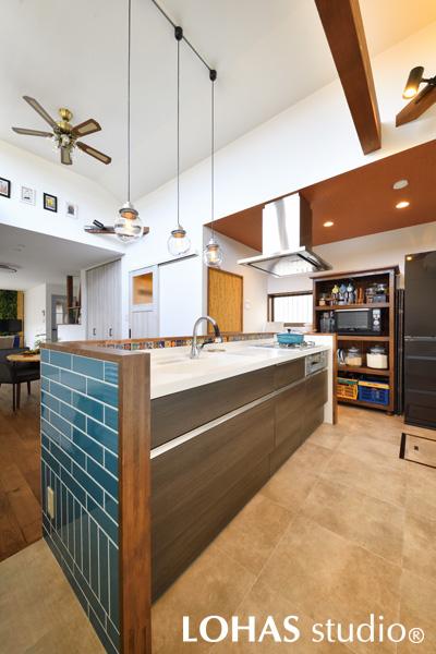 奥から大移動してきたキッチンは、I型キッチンを高さを抑えた腰壁で囲うことにより、価格を抑えながらアイランドキッチン感覚を実現させました。大好きなターコイズブルーのタイルを使うことで、家のシンボル的存在となっています。