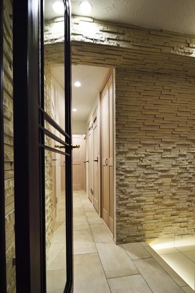 自然な凹凸のあるアイボリー系タイルを壁施工した玄関です。建具や床にも明るい色を揃え「狭くなったはずなのに全然狭く感じません」。ホテルのようにラグジュアリーです。