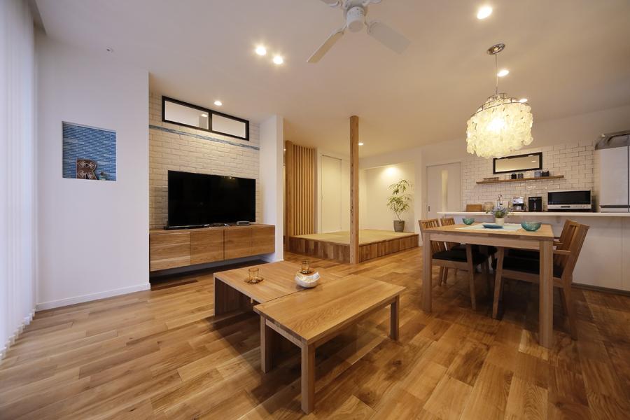 テレビボードの背景に白いブリックタイルを施工した上品な印象のリビングです。天井のシーリングファンが広いLDKに空気の流れを作ります。壁のニッチが素敵なインテリアに。