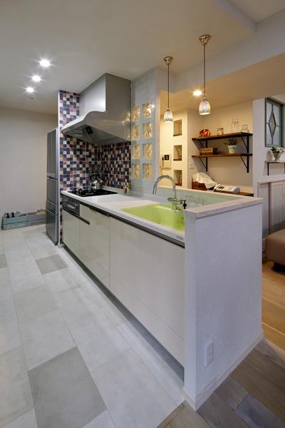 リビングに対面する爽やかなキッチンです。床には石の質感を持つタイルを施工。コンロ側にはモザイクアートのようなタイルを施工して楽しい雰囲気に。ダイニングにつながる動線を造り閉鎖的な雰囲気を解消しました。