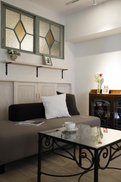 ステンドグラスでクラシカルな装いのリビングです。天井の段差で生まれた影のグラデーションで趣きある室内観に。パイン材で便利な収納棚を造作。同様にパイン材でオリジナル扉(LDK)をご用意しています。