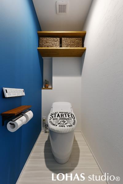 アクセントカラーのブルーが爽やかな印象のトイレです。マグネットの下地材を入れているため、壁に穴を開けることなくポスターや写真を貼って楽しめます。奥まったわずかなスペースも逃さずに、ちょっとしたモノを飾るのにぴったりなニッチ（飾り棚）に仕立てました。