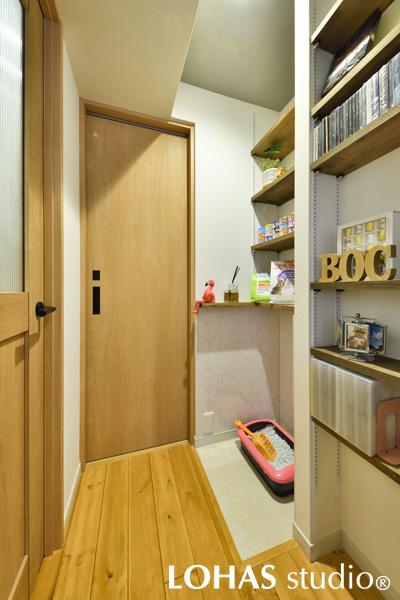 ご希望にもあった、ネコちゃん用のトイレスペースです。この部分だけ、消臭効果のあるペット対応の床材に変更しています。壁の棚にはネコちゃん用のフードやトイレの砂など、関連するものをまとめて置けて便利です。