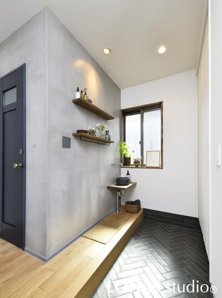 ゆとりのある玄関には、帰ってきてすぐに手を洗える便利な手洗いコーナーが。ヘリンボーン貼りのタイルやモルタル風の壁と意匠性にもこだわって、「ホッ」と脱力して素足でくつろげるような場所を目指しました。