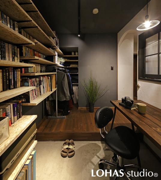 風格あるご主人様の趣味室です。玄関と居室の中間にあたりどちらからも入室OK。土間中心という独特の間取りです。コレクションの書籍やカメラ、レコード類は壁沿いに造作したオープン棚に整理収納。黒フレームの室内窓を設けました。