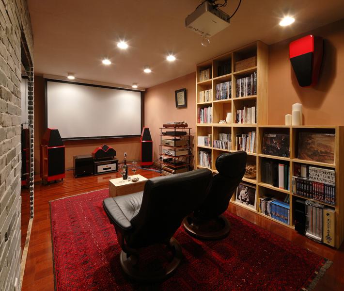 趣味の時間をゆったり過ごせる多目的リビングです。左の壁を延長しワインを納めるホームセラーを埋め込んでいます。書籍類は天井サイズの大きなオープン棚へ。
