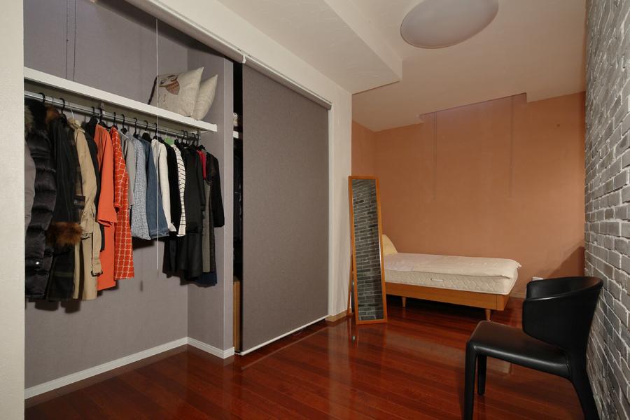 オープンスペースの奥に移設した寝室です。下がり天井沿いにクローゼットを造作、ロールスクリーンで目隠しをしました。クローゼットの壁でベッド上の目線は妨げられ囲まれ感のある落ち着く気分に。