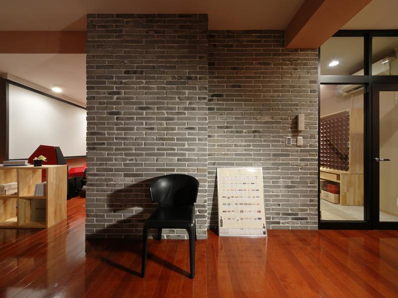 寝室・リビング・ワインセラーへの動線が集まるホールです。ブルックリン調のタイルが お洒落な装いです。 正面に見える壁を延長して幅員を増やし室内側にワインセラーを埋め込みました。 ご所有品のイタリア製家具が素敵に馴染んでいます。