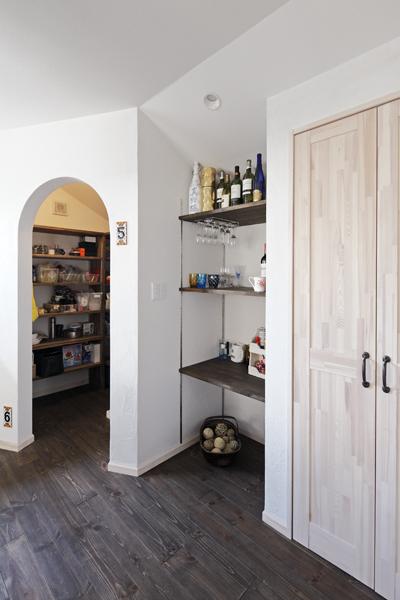 キッチン近くに造作した収納スペースとバーコーナーです。左)アーチの開口部は洗濯機も収まる大空間のパントリー。中)凹んだスペースはご夫婦がお酒を愉しむバーコーナー。右)扉付きの収納です。収納コーナーを集め充実させることでLDKはいつもスッキリ！