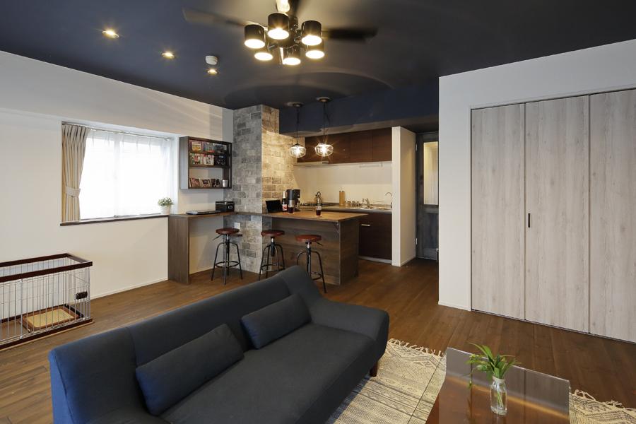 壁はしっくい、床は無垢材をご採用、夜空のような天井に心安らぐLDKです。隣室の和室を組み込んで広さを約2倍に、収納は見た目も意識してデザインしました。ブリックタイルと木製カウンターはアメリカン・ヴィンテージ調です。