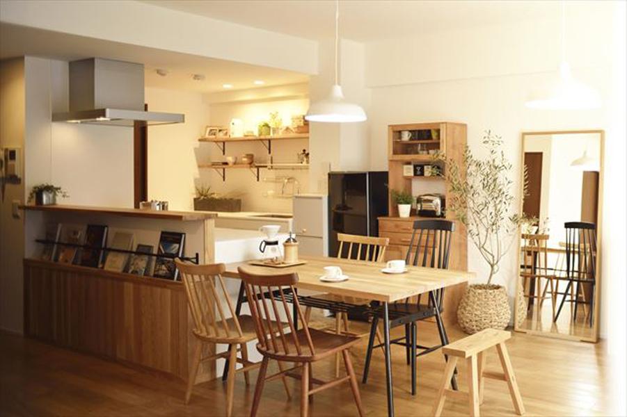 2部屋分を使った開放的なLDKです。既存の壁を1面取り去り広い面積を用意しました。テーブルや置き鏡など木製家具も素敵に調和したナチュラルな景観です。