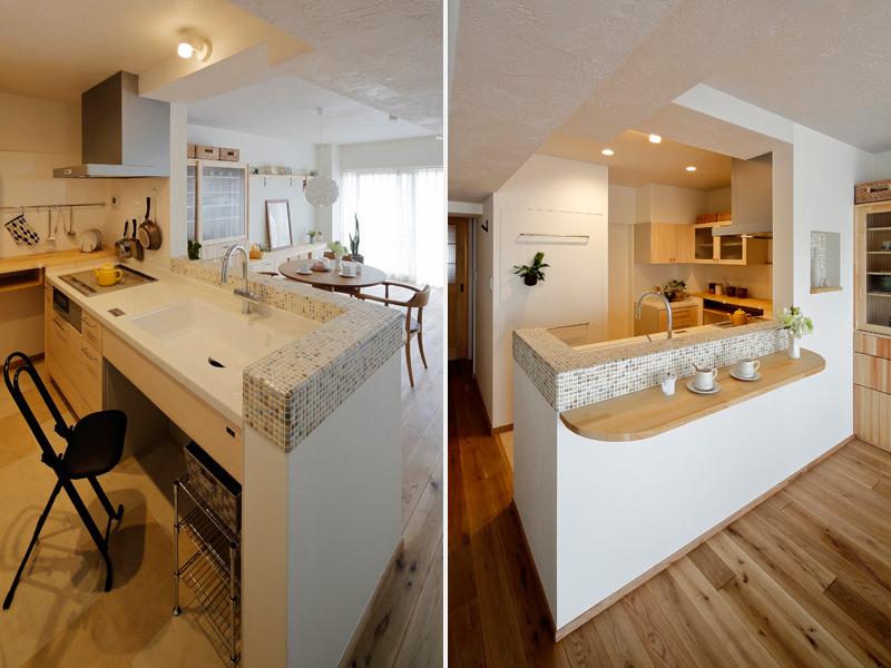 シンク周辺をタイルで彩った可愛らしい対面キッチンです。奥にある『コの字』空間にパイン材でカウンターを造作。吊戸棚など収納も完備。床は耐久・耐水性に優れたPタイル（プラスチックタイル）製。