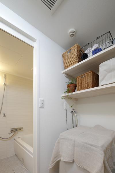 あまり広くない脱衣所で収納を確保する為、洗濯機の上部のデッドスペースに造作棚を設置。扉のない造作棚なので圧迫感を感ずスペースを広く見せるよう工夫。