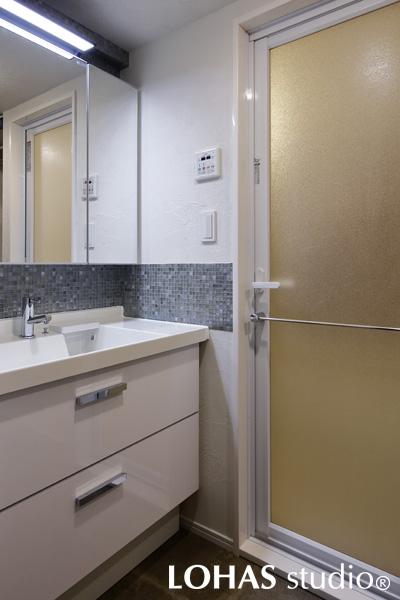 ホワイトで明るい洗面まわりです。壁面の一部にはガラスタイルでアクセント付けを施しました。意匠性を高めるだけでなく、ちょうど水のはねやすい部分をタイルにすることで、水まわりのお手入れがラクになるというメリットも。