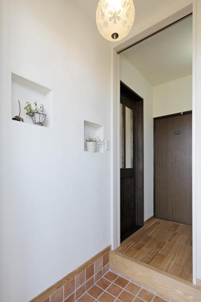 二世帯の共用玄関です。直進すれば親世帯へ、右に行けば子世帯へ直結しプライバシーを守ります。真正面には親世帯が丸見えにならないよう間仕切りを新設しました。上吊タイプの引き戸のため床へのレール設置は不要。歩行にも安心です。