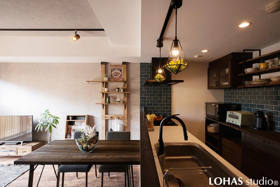 吊り戸を撤去した代わりにライトを下げて、カフェのような仕上がりになったキッチン周りです。また、家具に合わせてカップボードやキッチンの水栓などのトーンも統一。細かなこだわりが空間全体の完成度を高めました。