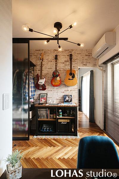 ワークスペースと収納を兼ね備えたアトリエの様子です。床はヘリンボーン張りにして印象的に仕上げました。楽器やレコードを収納する面にデザインクロスを施したことで、まるでお店の一角のような雰囲気に。