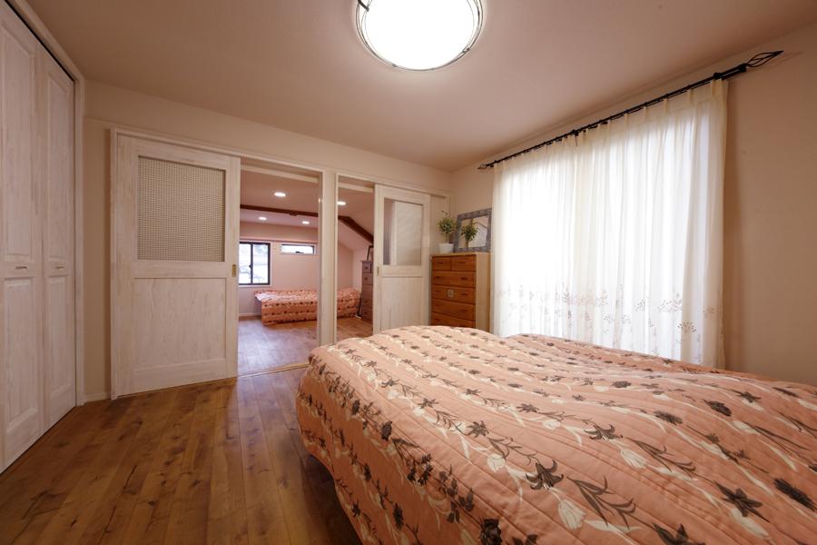 リビングに続くご夫婦の主寝室です。リビングとの境目はオリジナルで造作した窓付きの引き戸。隣室からも光が通り明るい室内です。子ども部屋にと奥の納戸は用途を変更しました。