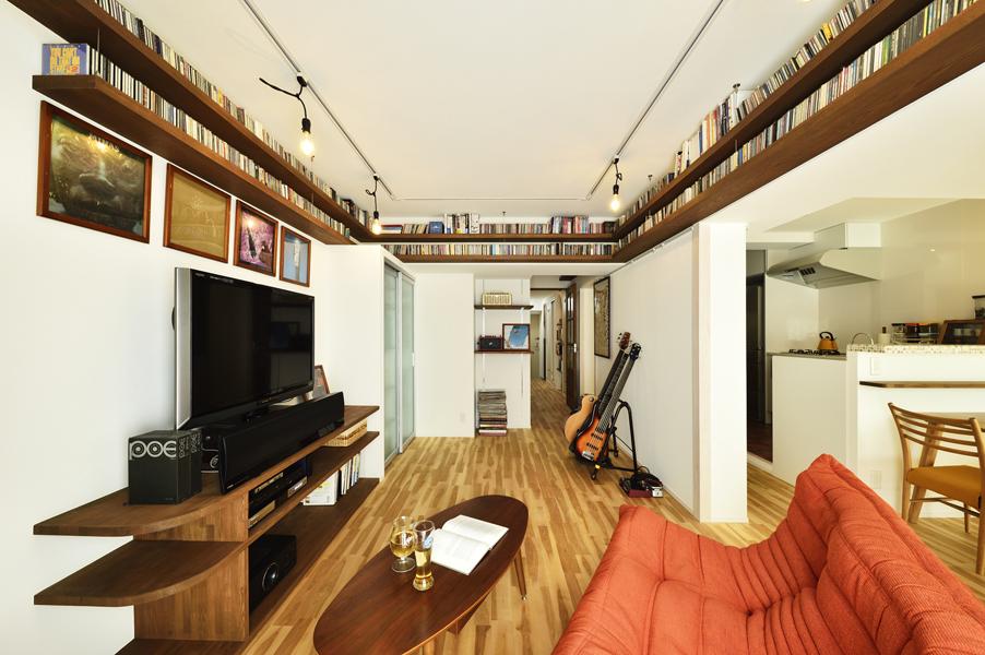 既存のなごり・構造壁の一部を間に挟む迫力あるLDKです。ムラ色がリズミカルな床はカバザクラの無垢材。建具も無垢材で造作しました。奥にオープン開口のフリースペースをご用意しています。