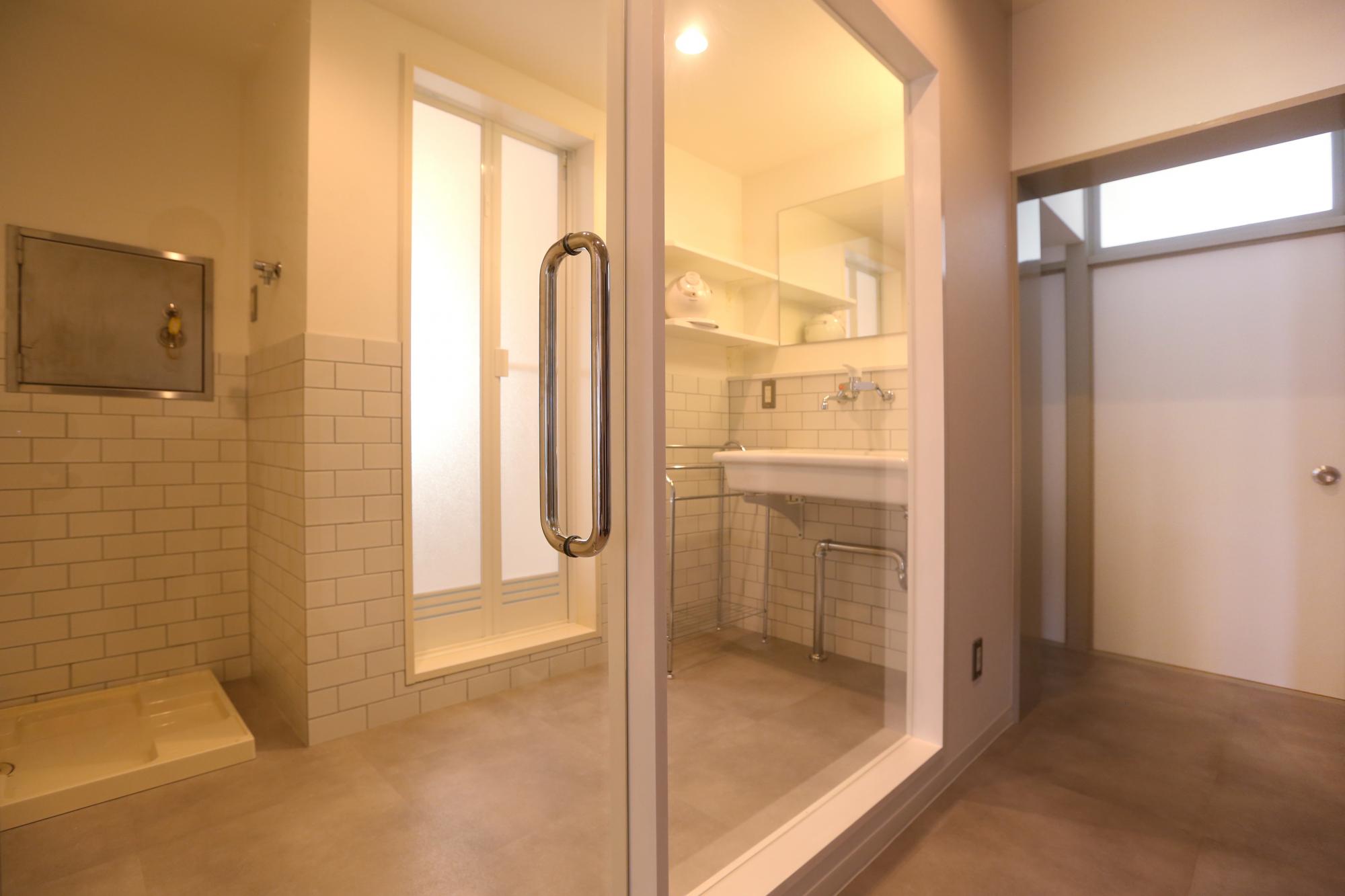 ホテルのような洗面所はモルタルの床とブリックタイルを採用