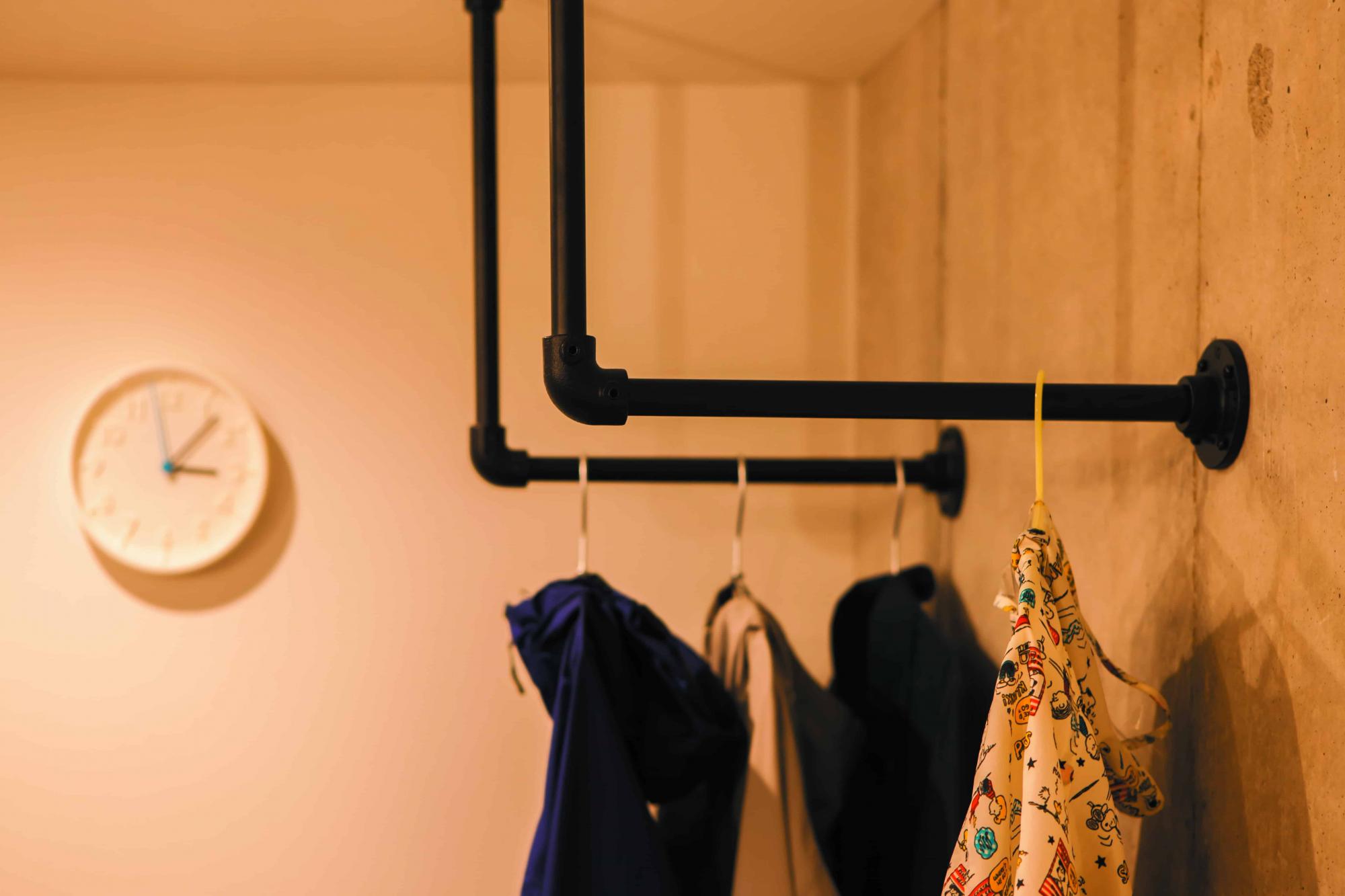 玄関にもハンガーパイプを設置。お出かけ用の服をかけておけます。