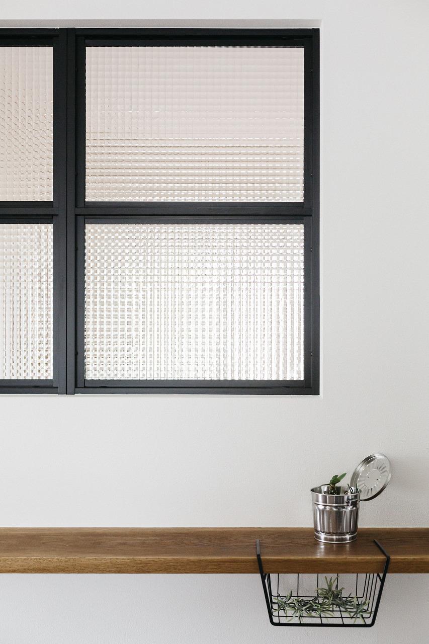 真っ白な壁に取り付けた造作の飾り窓。