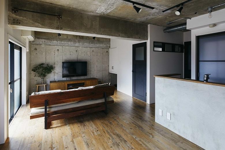 コンクリートをむき出しにした武骨なLDK。照明や換気扇のダクトもそのままデザインとして取り入れています。