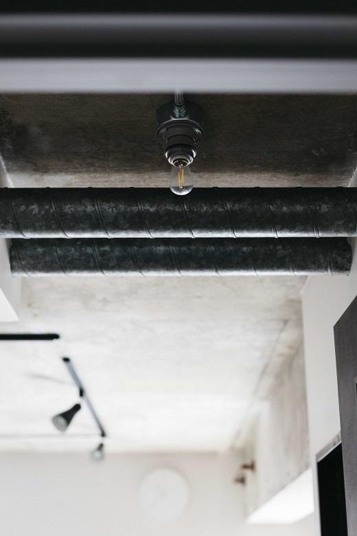 むき出しの配管と照明がインダストリアルなテイストを強調しています。