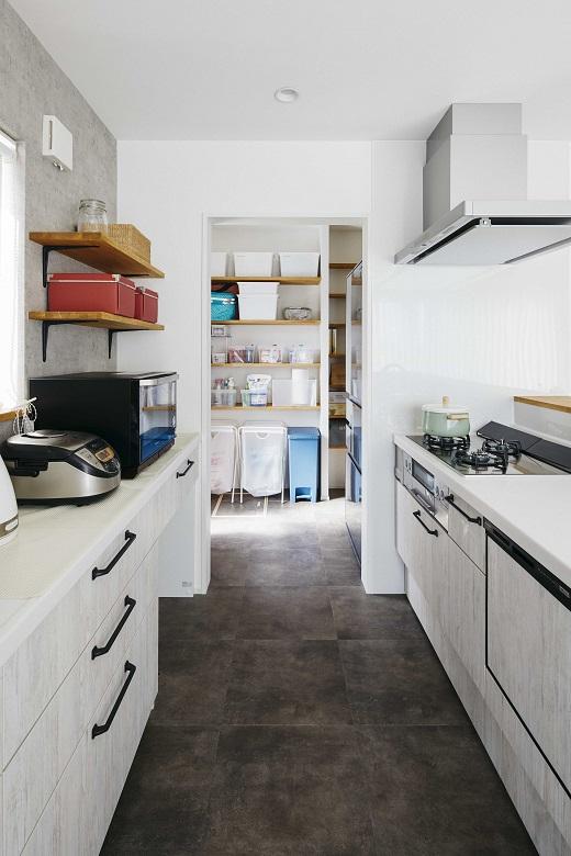 キッチンにはダークなコンクリート調の床材を採用し、メリハリあるデザインに。