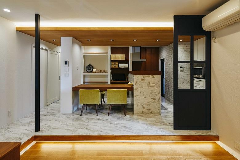 リビングとダイニングの間にはあえて段差をつけて空間を緩やかに仕切っています。床と天井の段差部分には間接照明を設置しました。