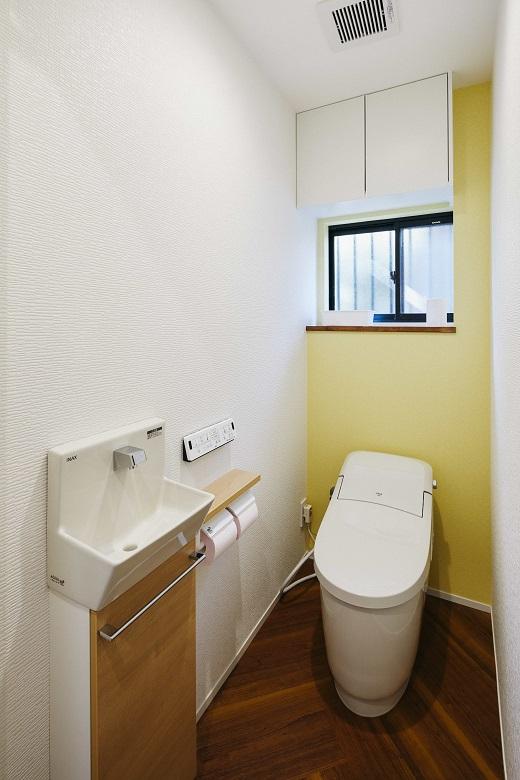 大き目のヘリンボーン柄の床を施したトイレ。