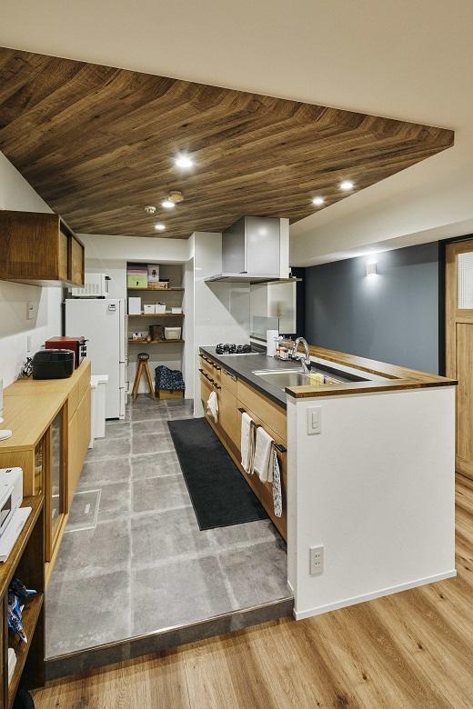 キッチンの横にはパントリーも設置。キッチンスペースは床を上げ、折り下げ天井にしたことで特別な空間に。