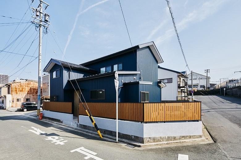 濃いブルーのガルバリウム鋼板と木目調フェンスで現代風に蘇った、築約40年以上のお住まい