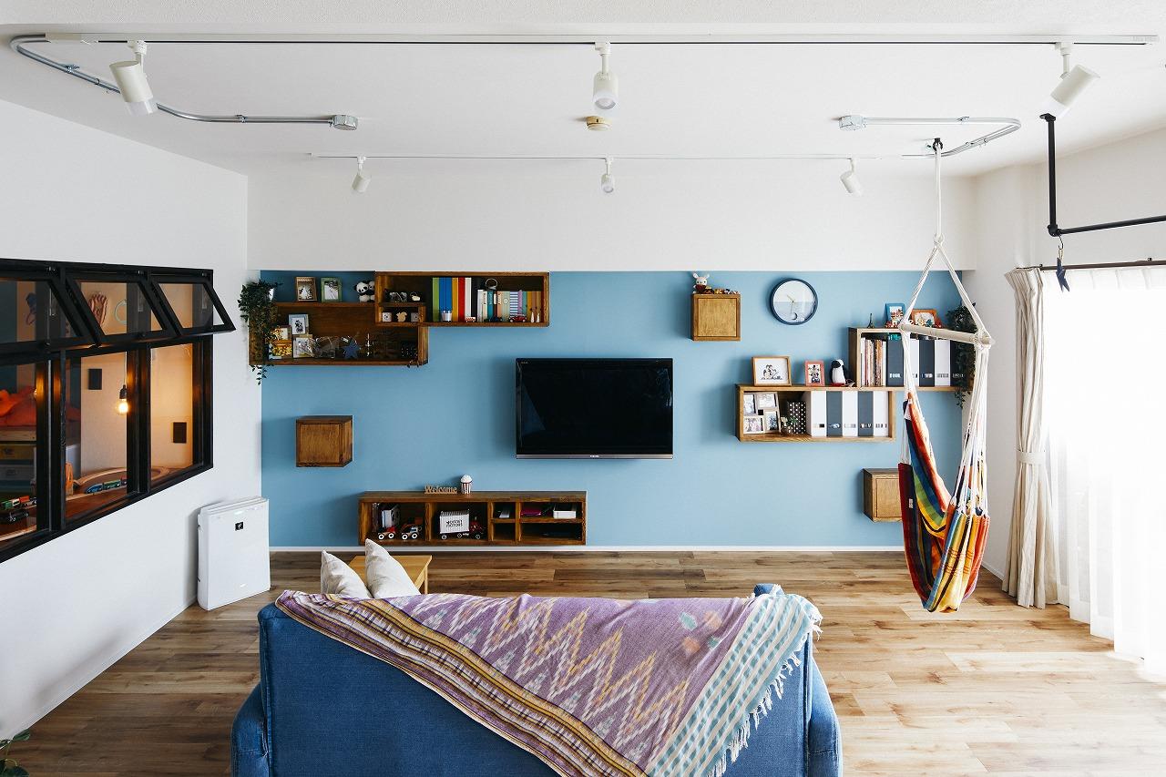 写真や本などを壁一面に収納できるマリンテイストなLDK。壁掛けTVもこだわりの一つ
