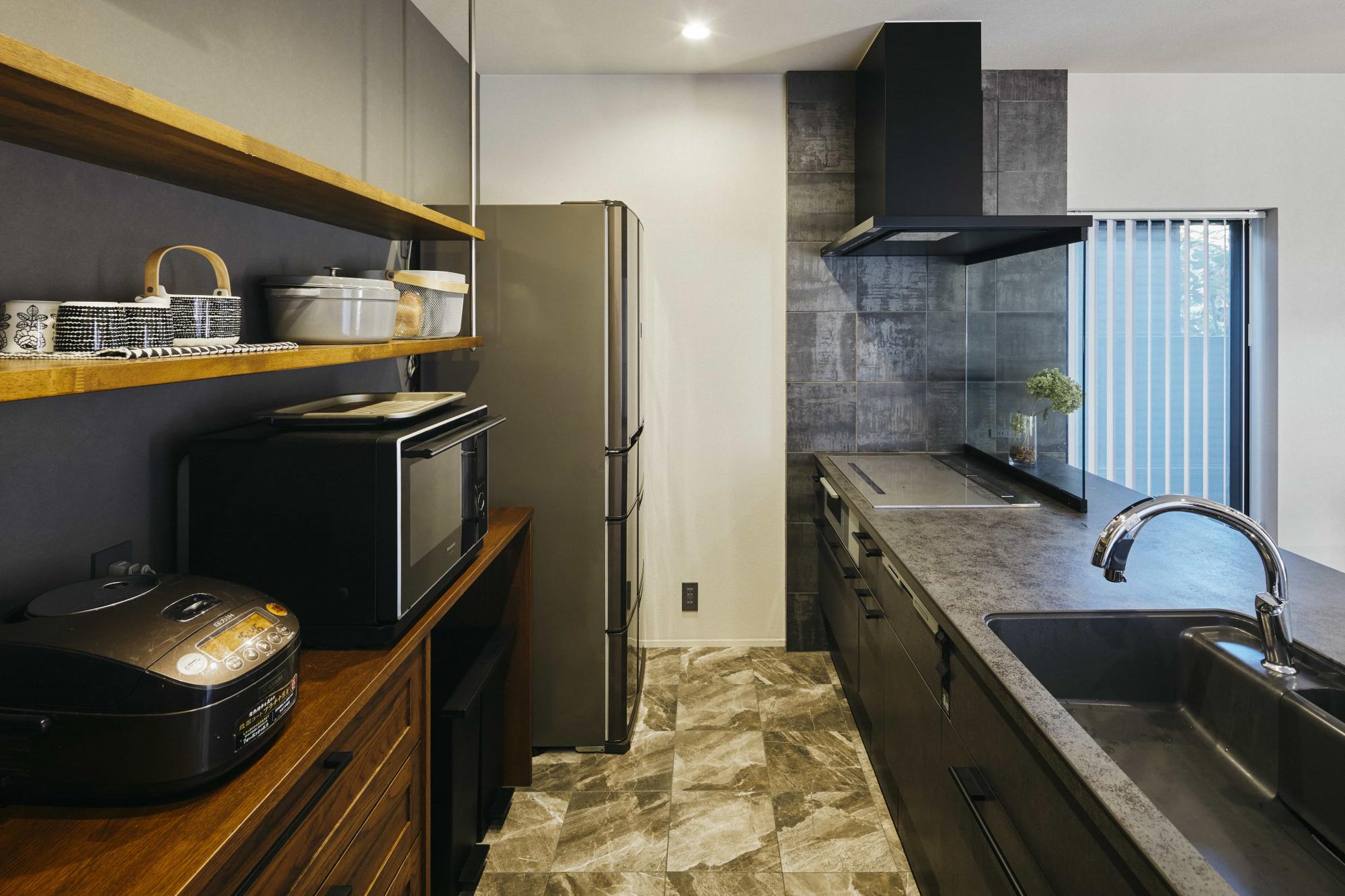 キッチンはリビングダイニングとは異なる大理石調の床材を取り入れました。