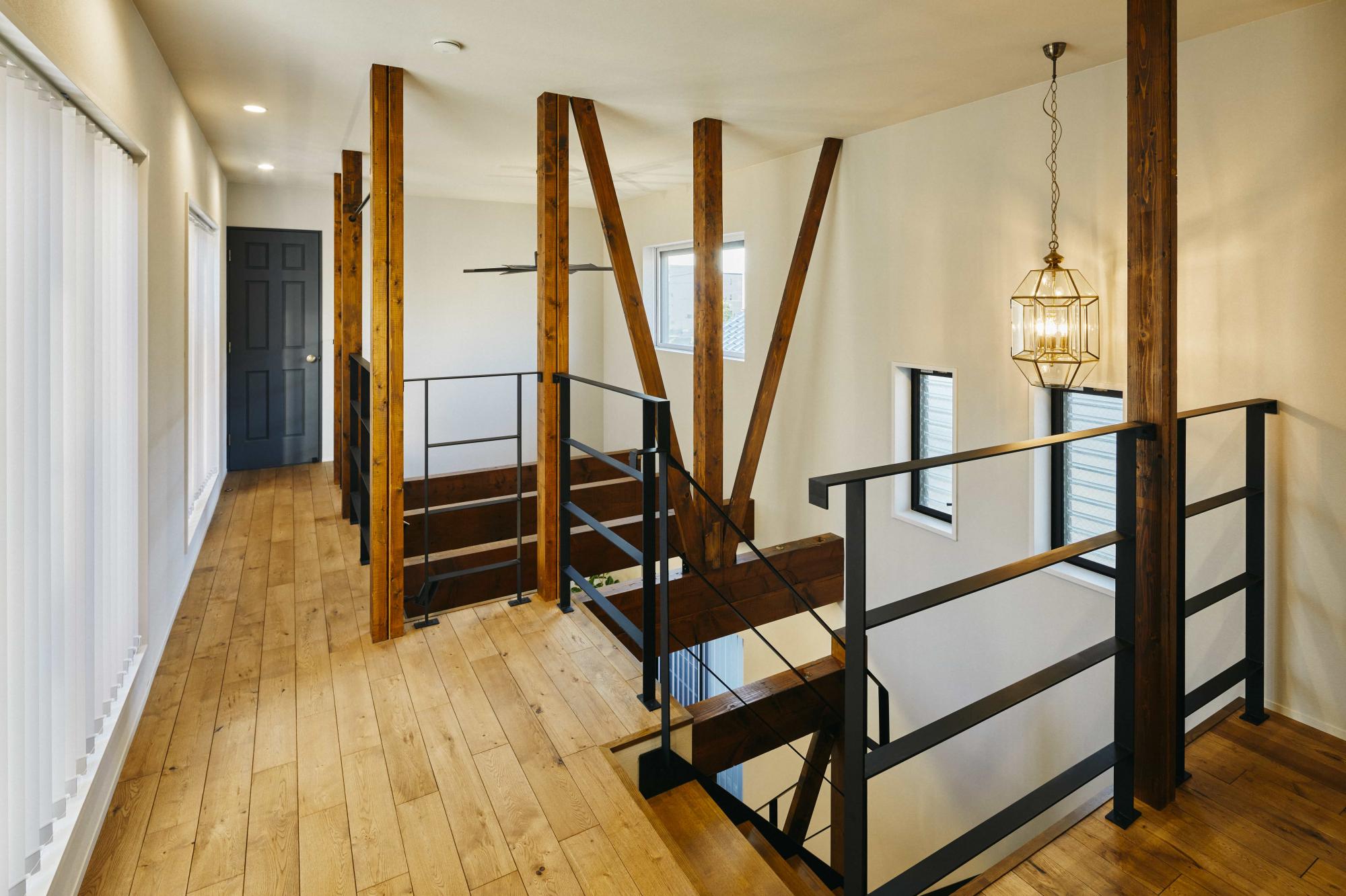 吹き抜け周りはアイアン手摺、建具は無垢材を採用。