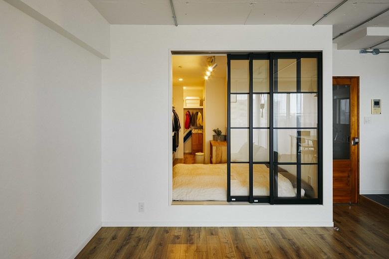 主寝室へと繋がる扉は、ベッドに合わせて高さをあげ、行き来も出来るし室内窓のようにも感じれる他にはないデザイン。