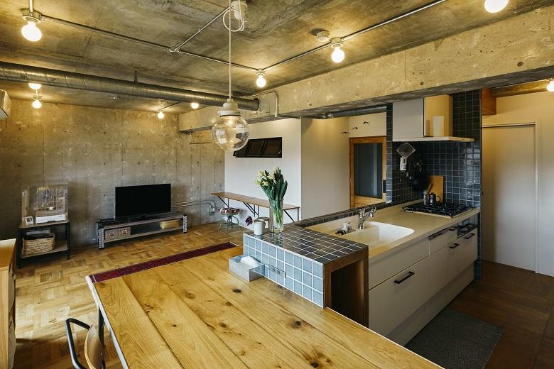 造作のキッチン一体型のダイニングテーブルには無垢材を使用。L字型で使い勝手のよいデザインです。